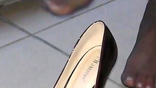 Dipping classic red high heels on balcony