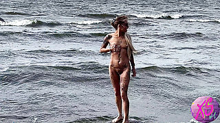 Beauty blonde walking naked on the seashore