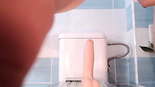 Busty Babe fucks a dildo in the bathroom