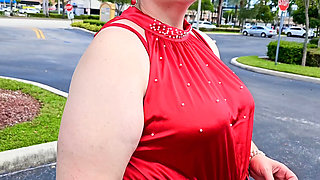 Beautiful woman walking outdoors in public parking lot showing off for strangers