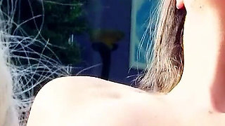 Two lesbian teens pamper each other on vacation at the pool