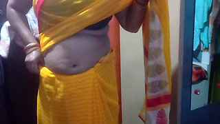 Indian housewife is wearing a yellow saree.